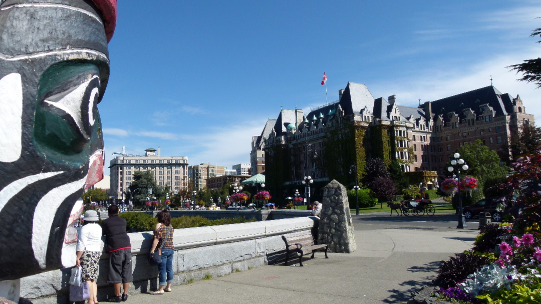 Kwakiutl Bear Totempfahl am Inner Harbor schaut auf das Empress Hotel von Antje Baumann